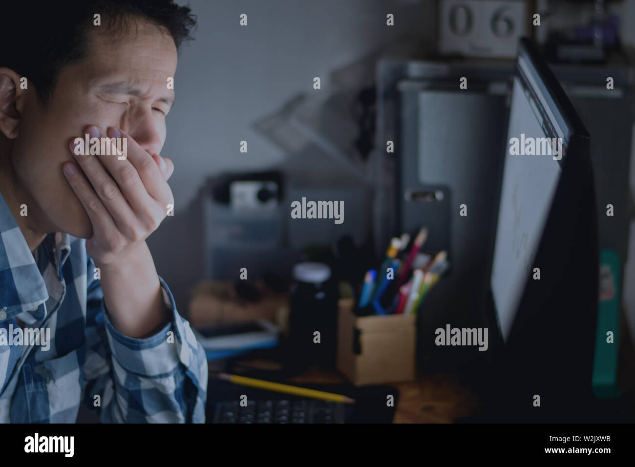 Men are gagging while yawning on the office desk in night time with overtime Stock Photo