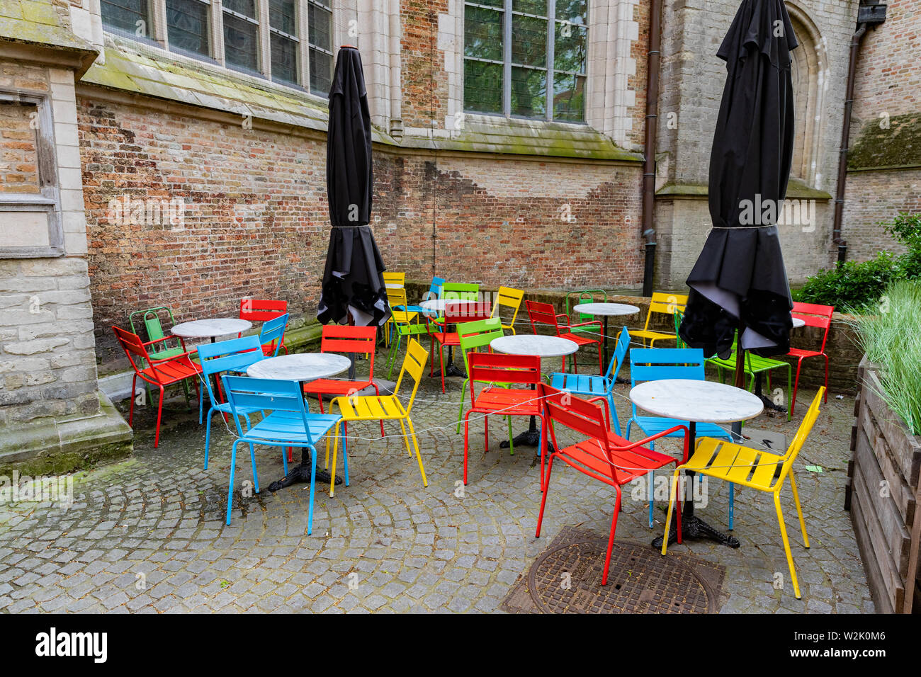Brightly Colored Tables And Chairs In Street Cafe In Bruges