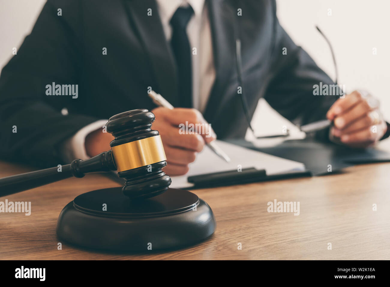 Legal law, advice and justice concept, counselor lawyer or notary working on a documents and report of the important case and wooden gavel, brass scal Stock Photo