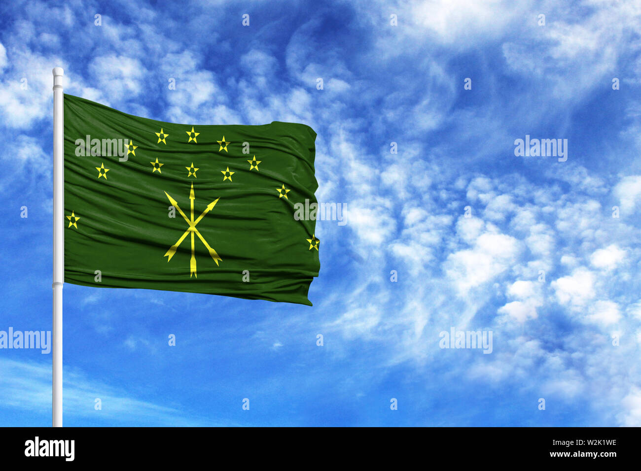 National flag of Adygea on a flagpole in front of blue sky Stock Photo