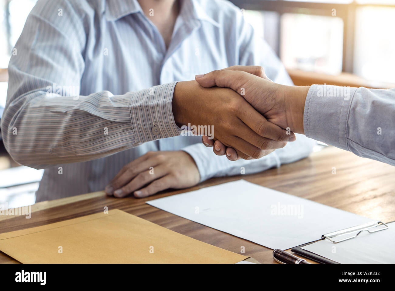 Finishing up a meeting, handshake of two happy business people after contract agreement to become a partner, collaborative teamwork. Stock Photo