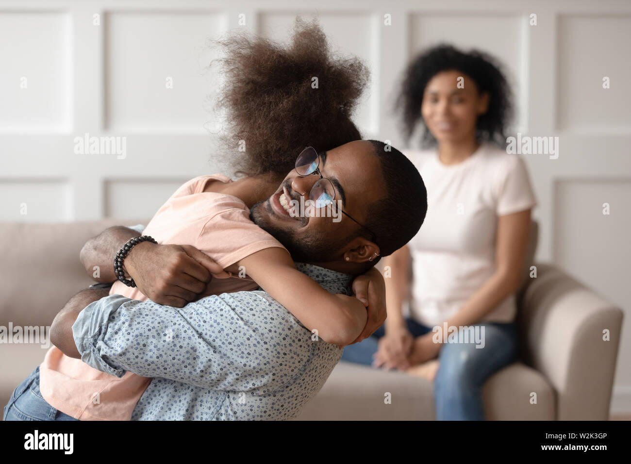 Happy african american dad embracing daughter cuddling at home Stock Photo