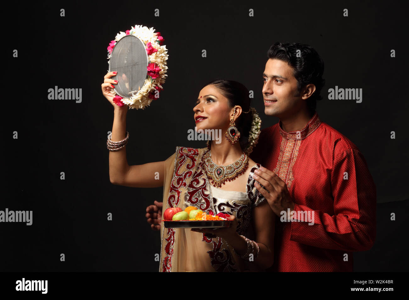 Couple looking through sieve during karwa chauth Stock Photo - Alamy