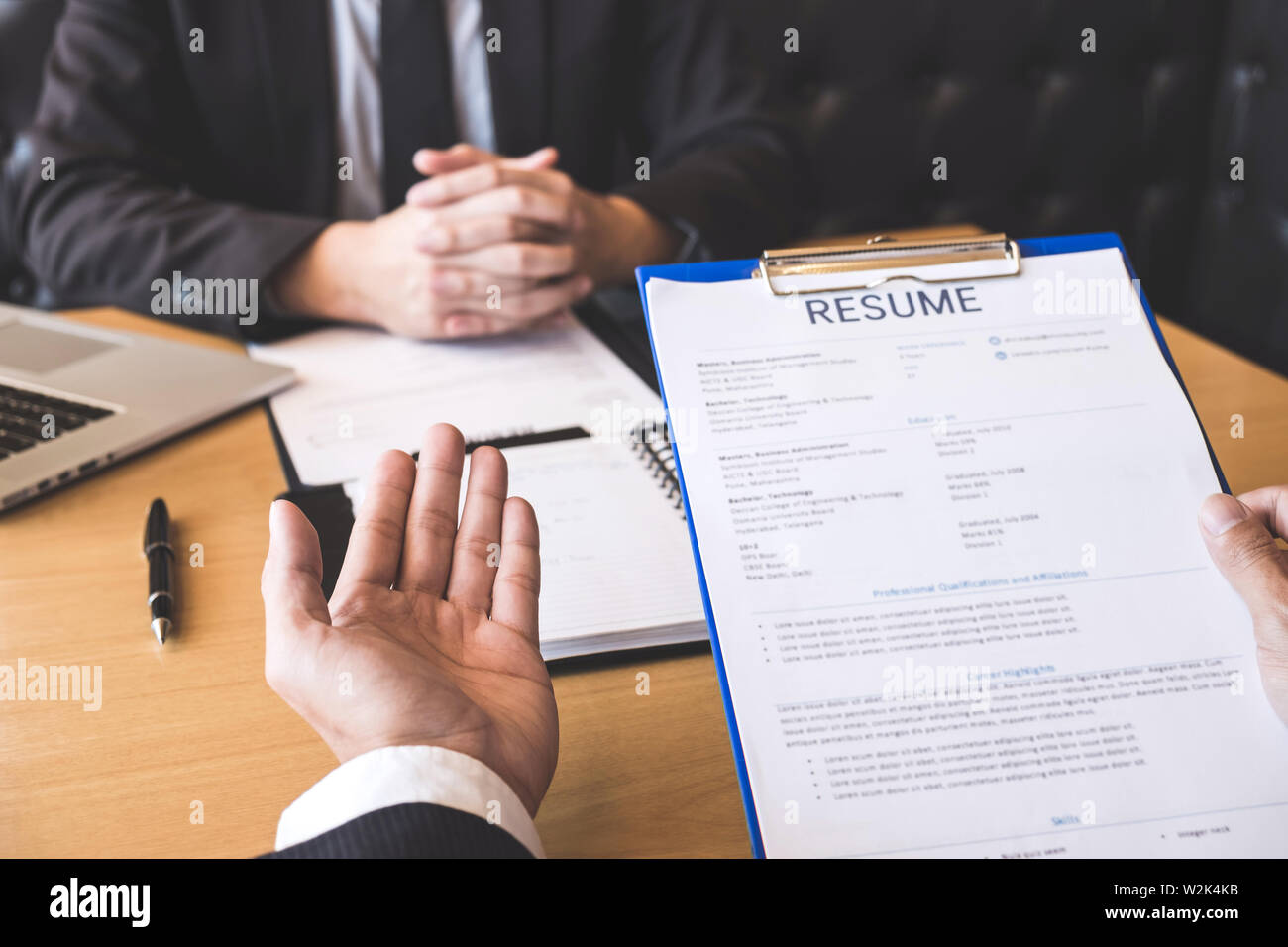 Closeup resume paper with qualifications on the desk during job interview  in the office with young applicant candidates and interviewer, discussing  on Stock Photo - Alamy