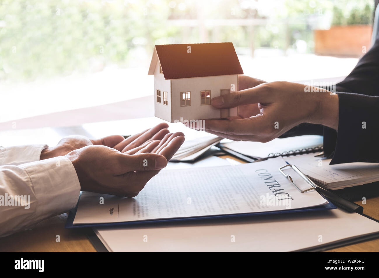 Estate agent sending house model to client after signing agreement ...