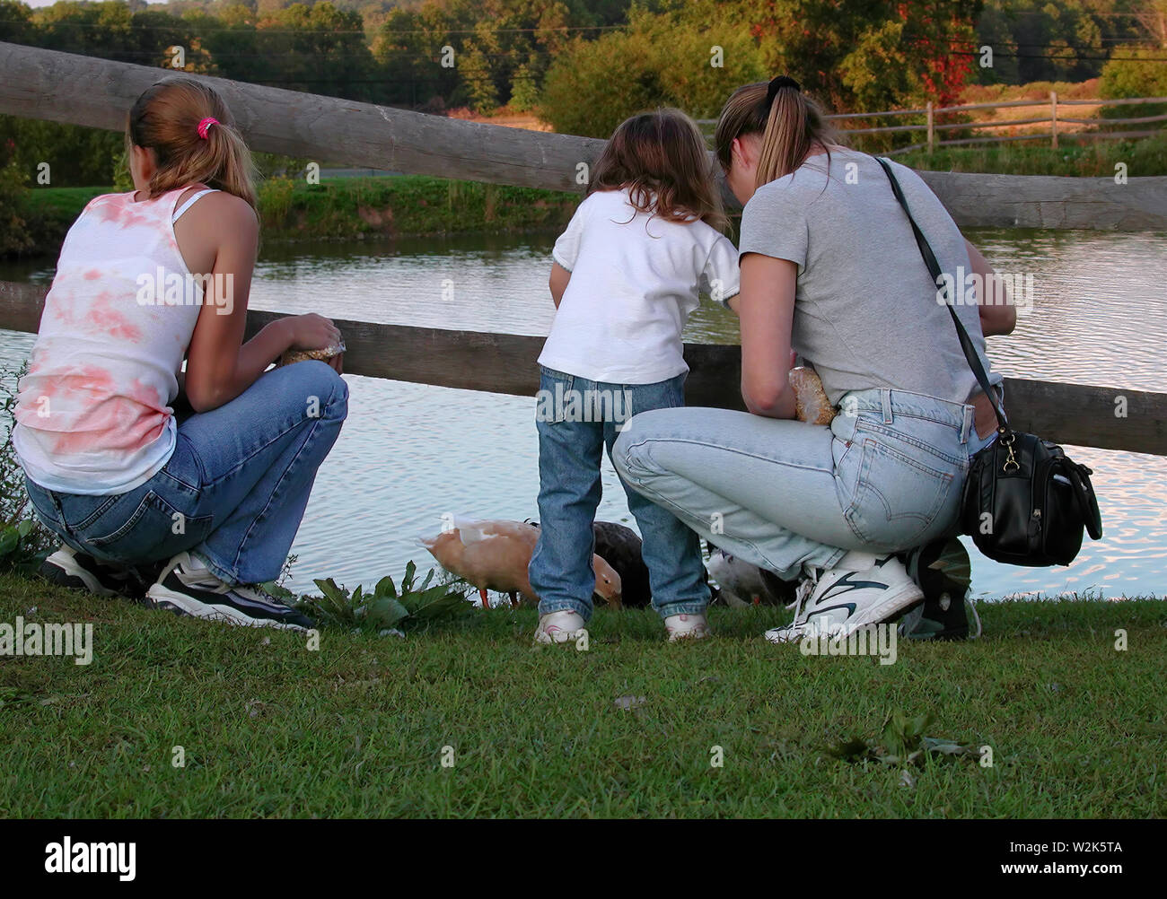 Middlefield, CT USA. Oct 2016. Young mother and daughters spending good quality time outdoors feeding ducks on a nice New England afternoon. Stock Photo
