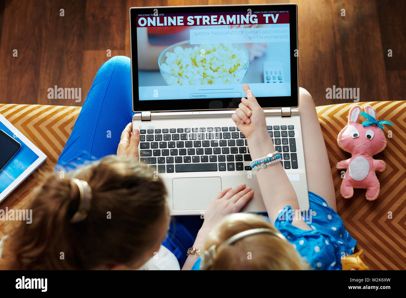 Young Mother And Daughter Sitting On Couch In The Modern Living