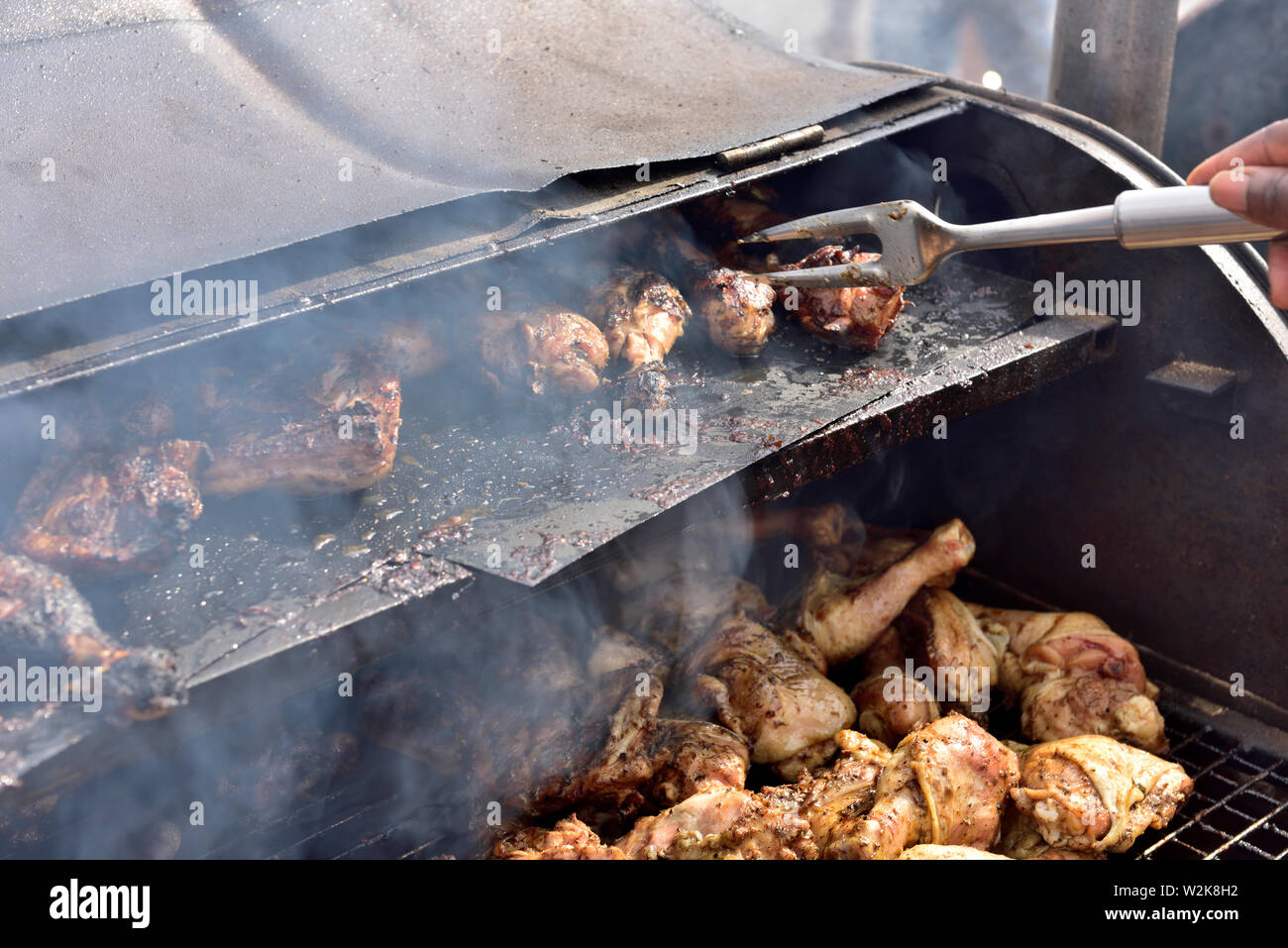 Barbecuing chicken pieces on oil drum barbecue at Bristol St Pauls  Carnival festival Stock Photo