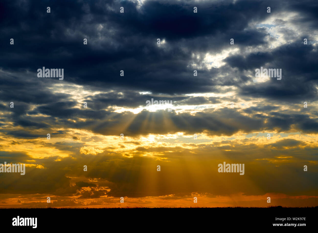 Beautiful sunset - dark sky with clouds and sunlight Stock Photo - Alamy