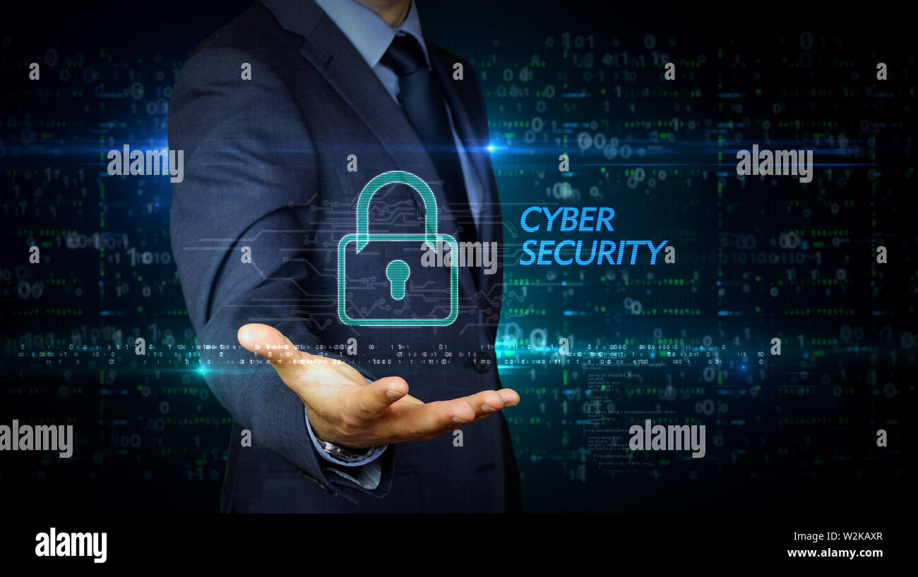 A businessman in a suit touch the screen with cyber security padlock hologram. Man using hand on virtual display interface. Digital protection and com Stock Photo
