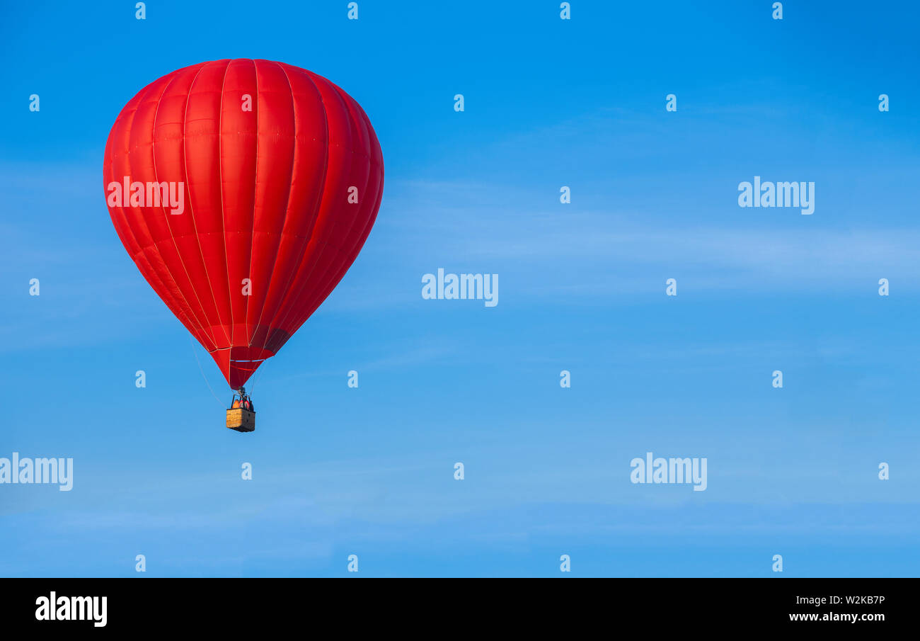Red hot air balloon in blue sky with white clouds Stock Photo - Alamy