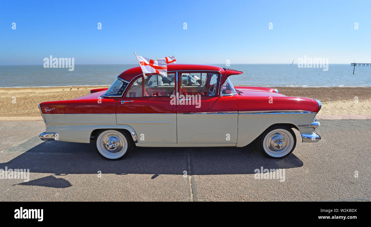 Classic Red and Cream Vauxhall Victor Super Motor Car Parked on Seafront Promenade. flying flags of St George. Stock Photo