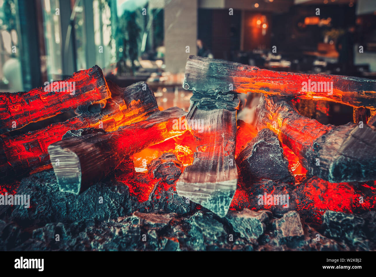 Interior of modern restaurant with fireplace close-up Stock Photo