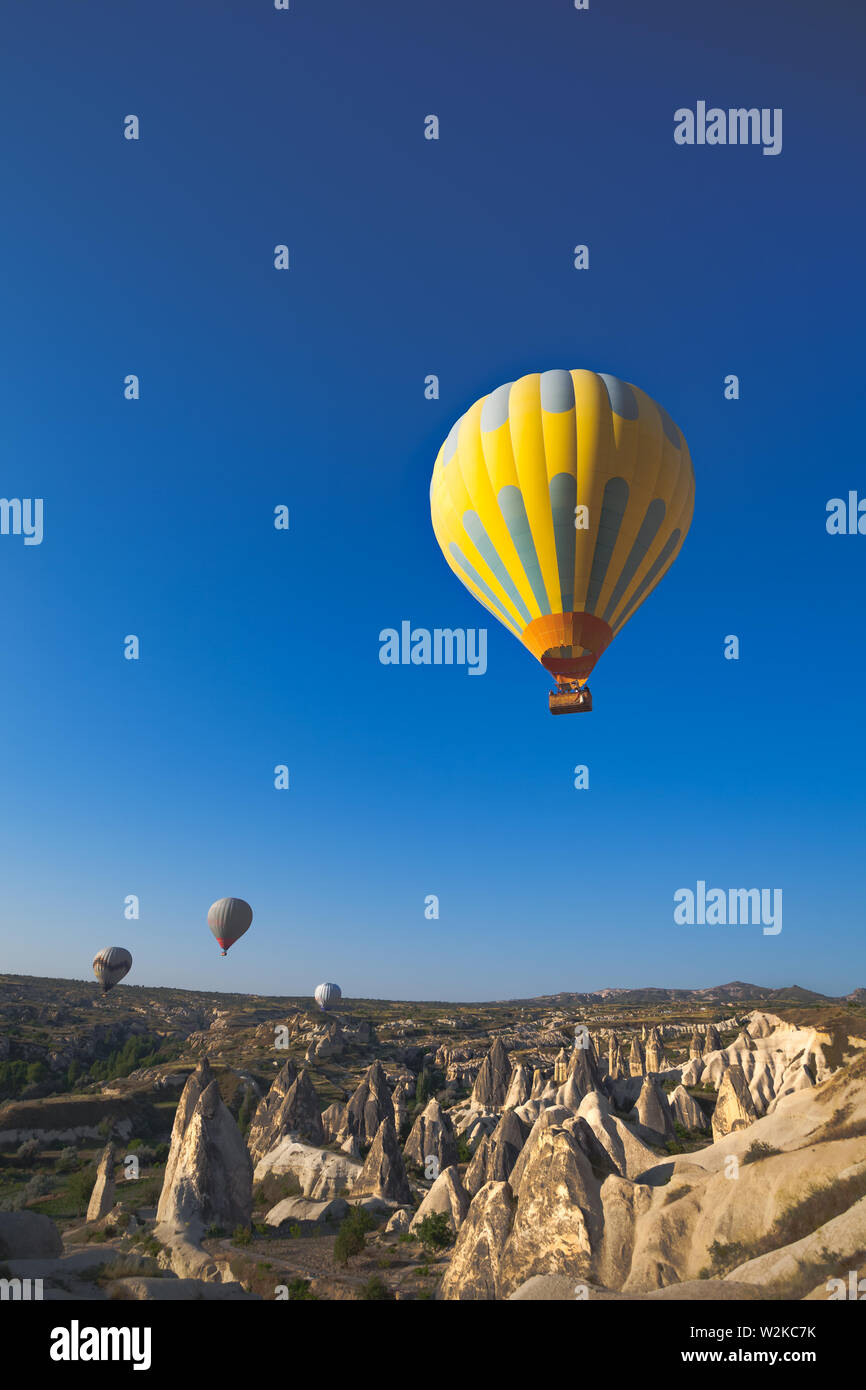 Hot air balloon flying over rock landscape at Cappadocia Turkey Stock Photo