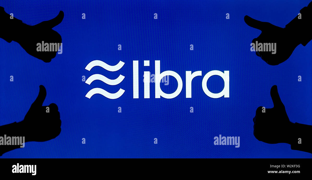 Facebook Libra cryptocurrency logo on the screen and the silhouette of likes around it. Conceptual to reflect perception of a new currency. Stock Photo
