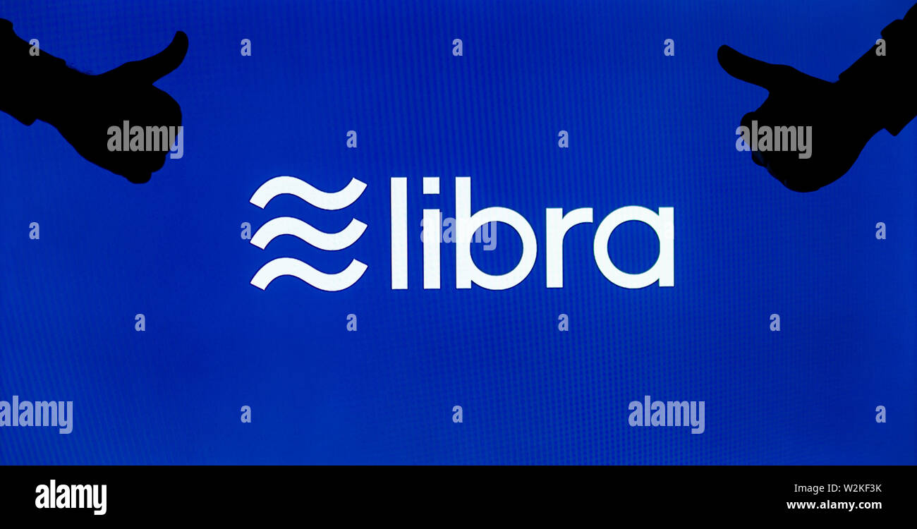 Facebook Libra cryptocurrency logo on the screen and the silhouette of likes around it. Conceptual to reflect perception of a new currency. Stock Photo