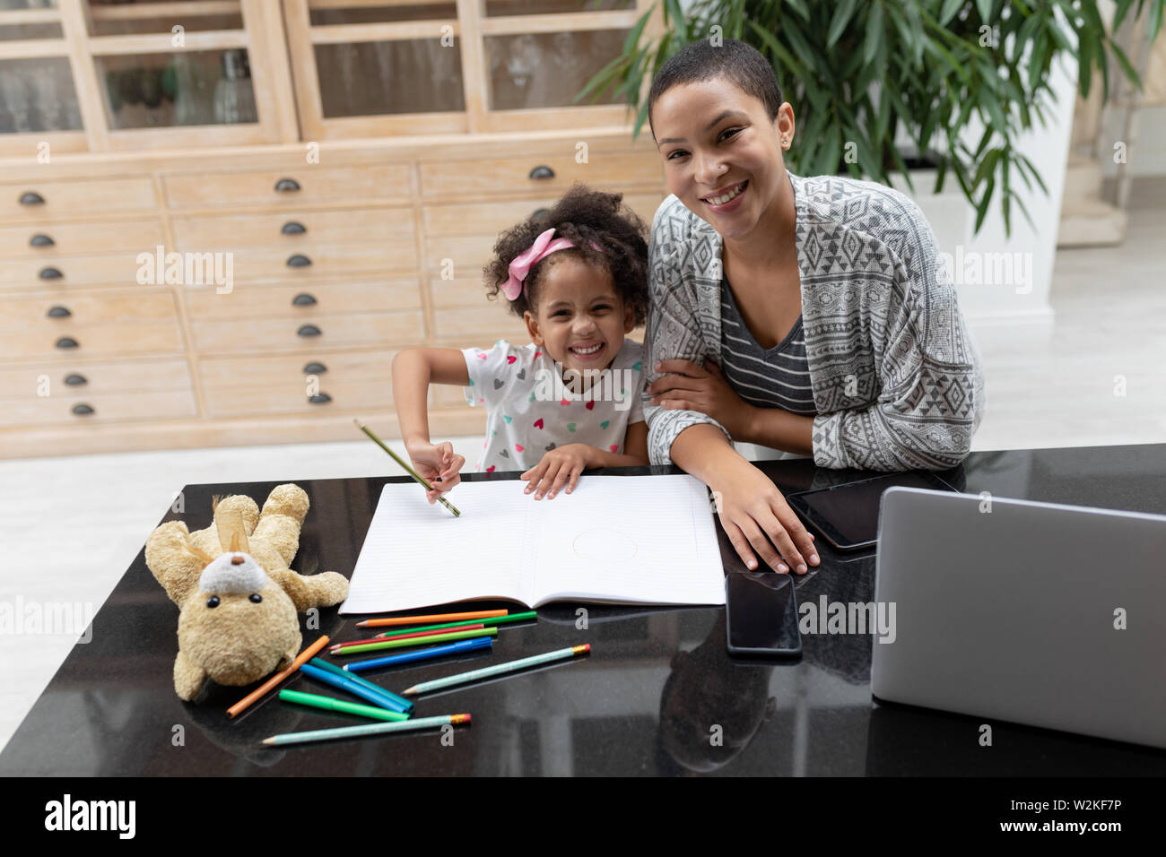 Mother helping her daughter with her homework on a table at home Stock ...