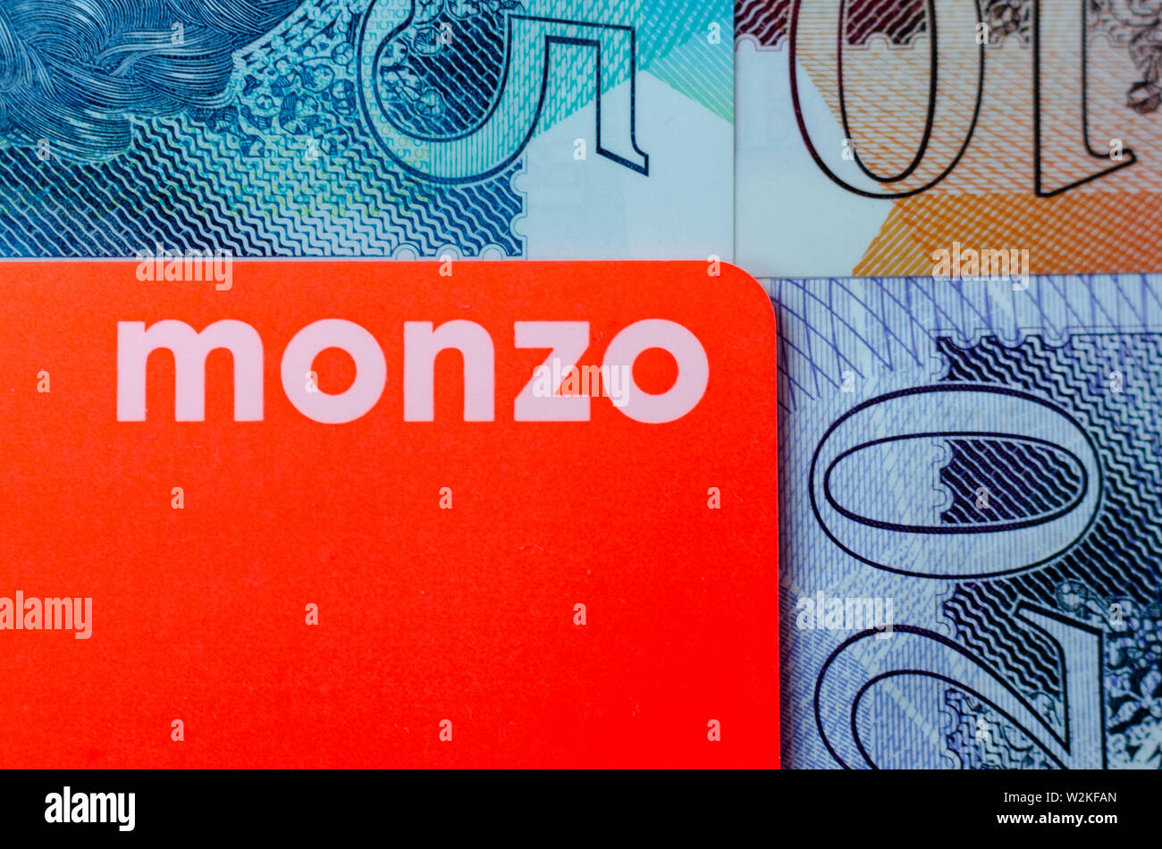 Monzo bank card on the background of the british pound cash different denominations. Stock Photo