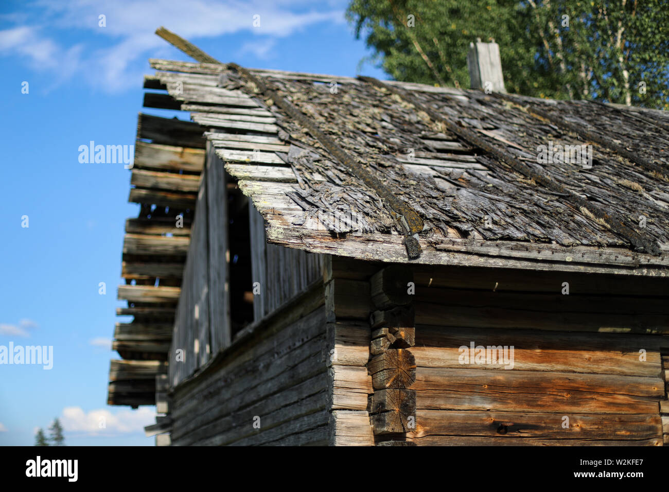 Wood shingle roof of an old weathered log barn in disrepair at abandoned farmstead in Ylöjärvi, Finland Stock Photo