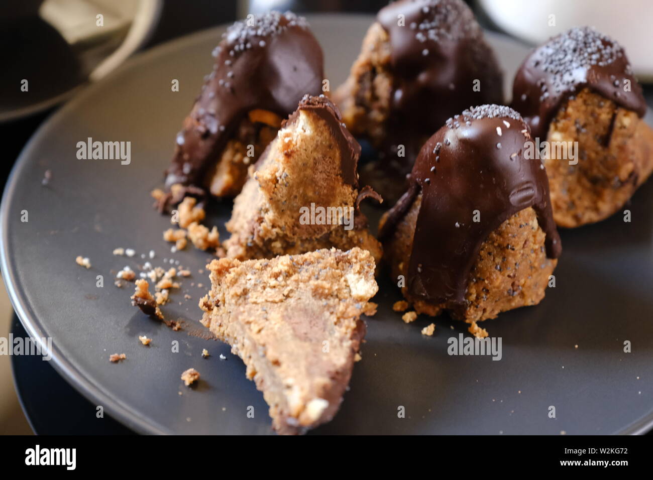 Anthill chocolate cake dessert on a gray plate. Black table in the kitchen. Bakery Stock Photo