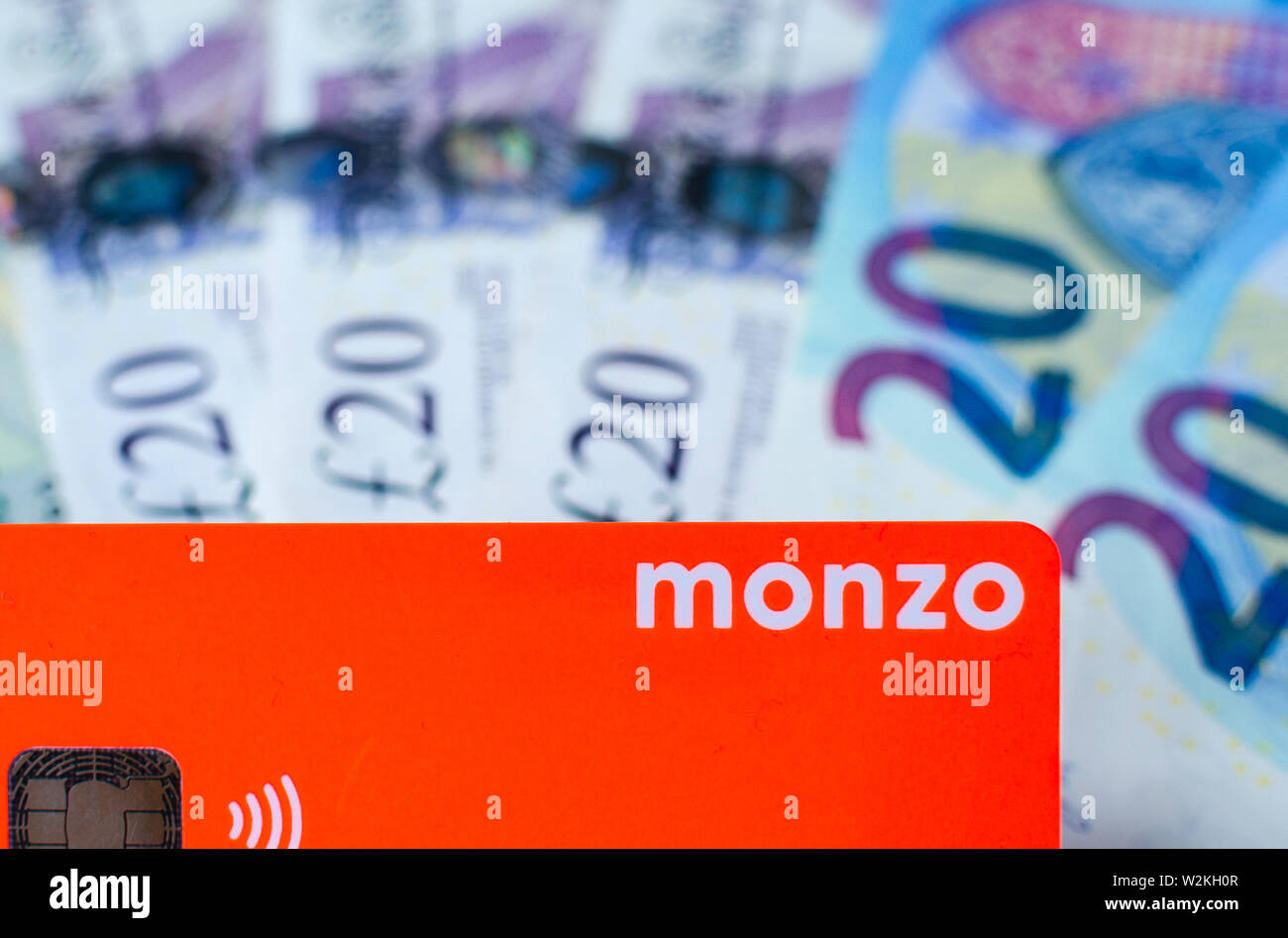 Monzo bank card on the cash of different countries. Card with no fee for money exchange is perfect for travel. Stock Photo