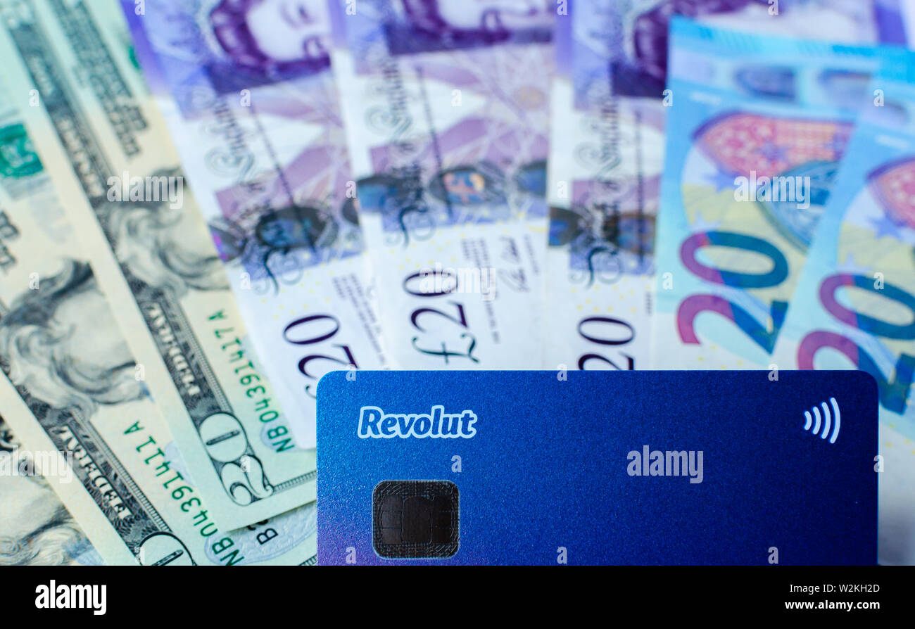 Revolut bank card on the cash of different countries. Card with no fee for money exchange and multicurrency account. Stock Photo