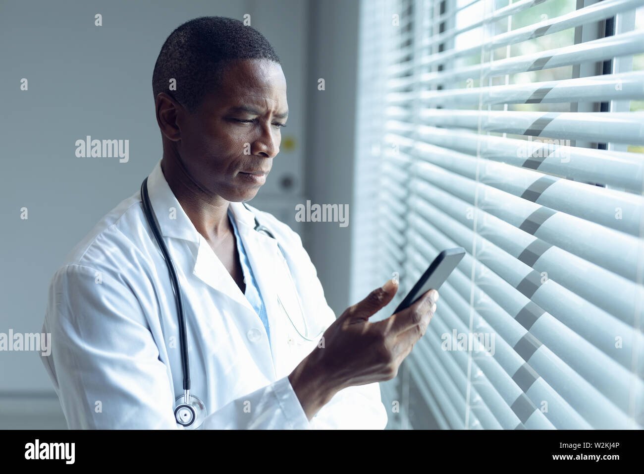 Male doctor using mobile phone in hospital Stock Photo