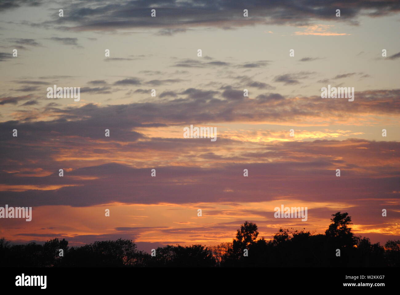 A sunset with thin layer of clouds in the sky Stock Photo - Alamy