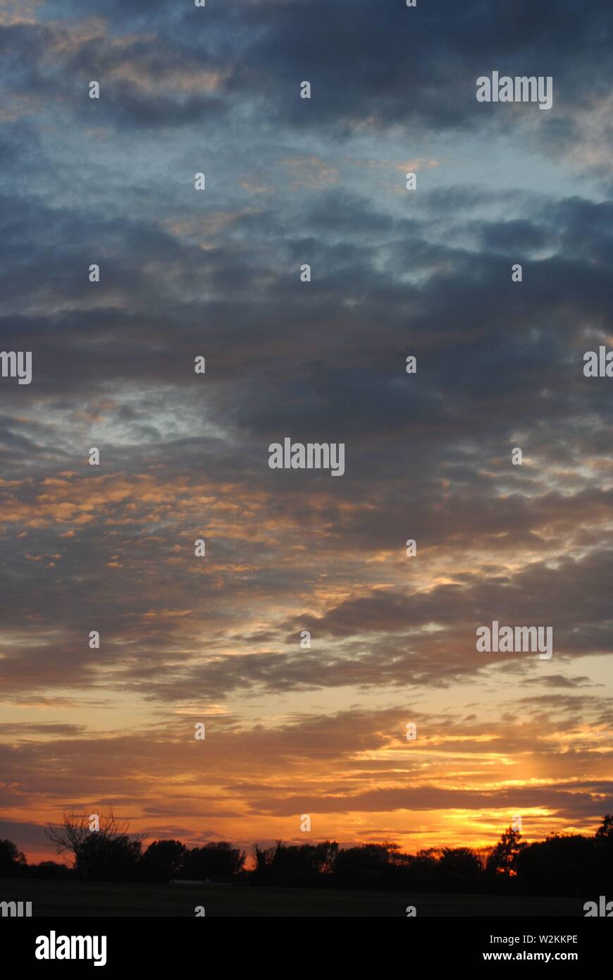 beautiful sunset with orange sky on the horizon and purple clouds and ...