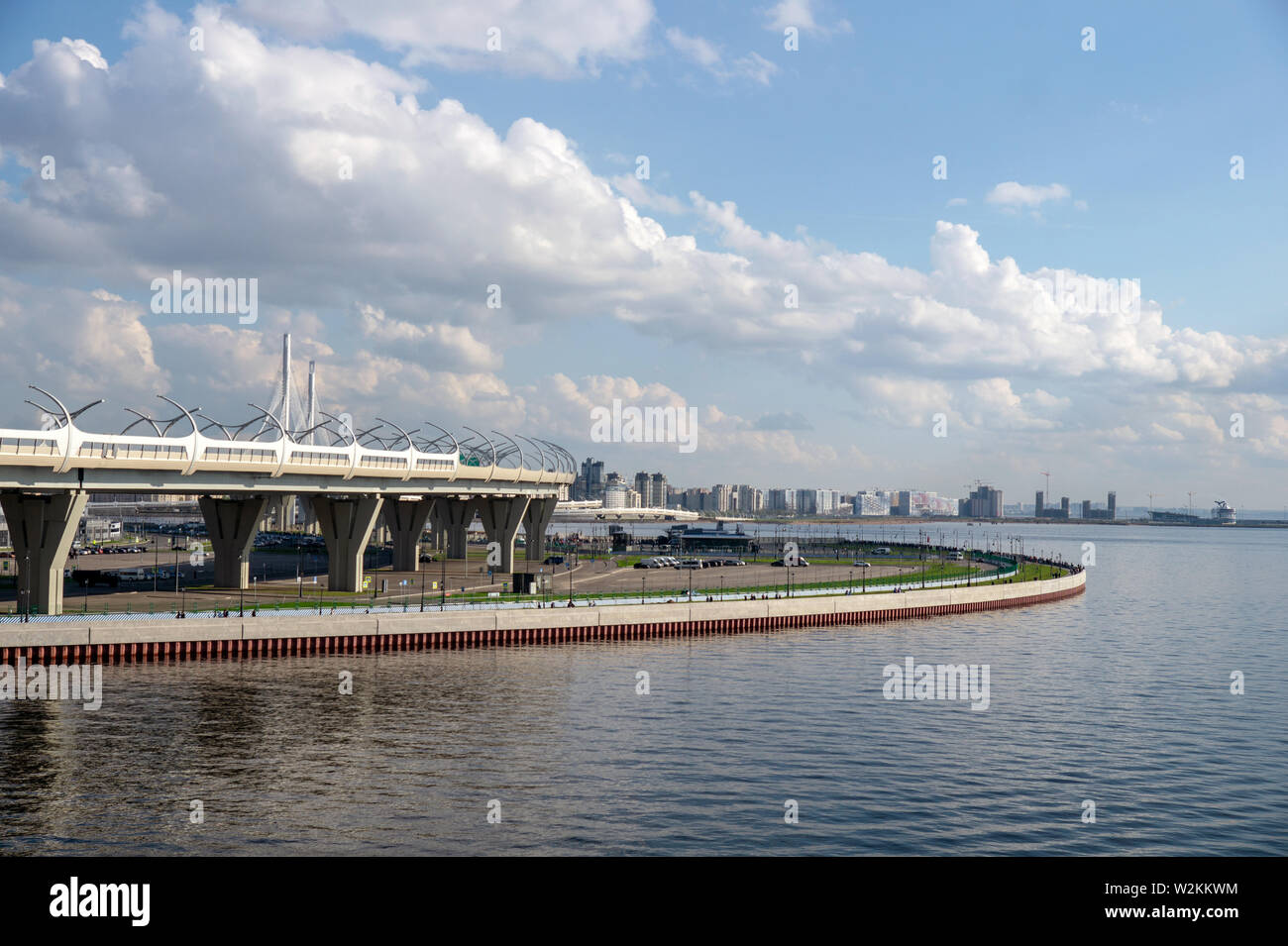 Bridge and embankment on a sunny summer day. City buildings in the background. Stock Photo