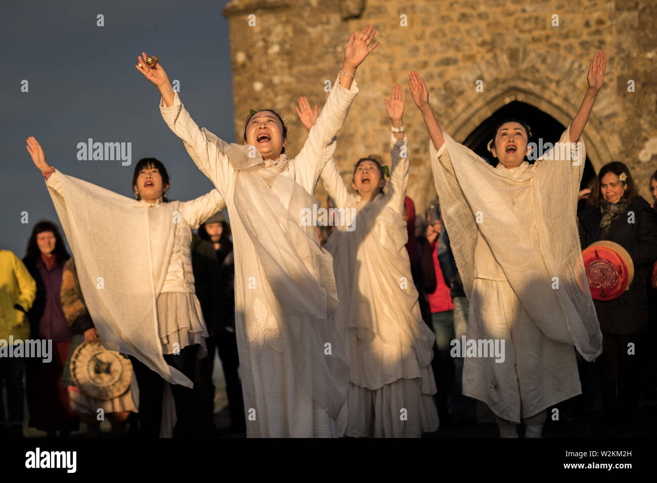 Glastonbury, UK. 21st June 2019. Revellers gather at sunrise on Glastonbury Tor for Summer Solstice celebrations welcoming the arrival of summer and the year’s longest day. Credit: Guy Corbishley/Alamy Live News Stock Photo