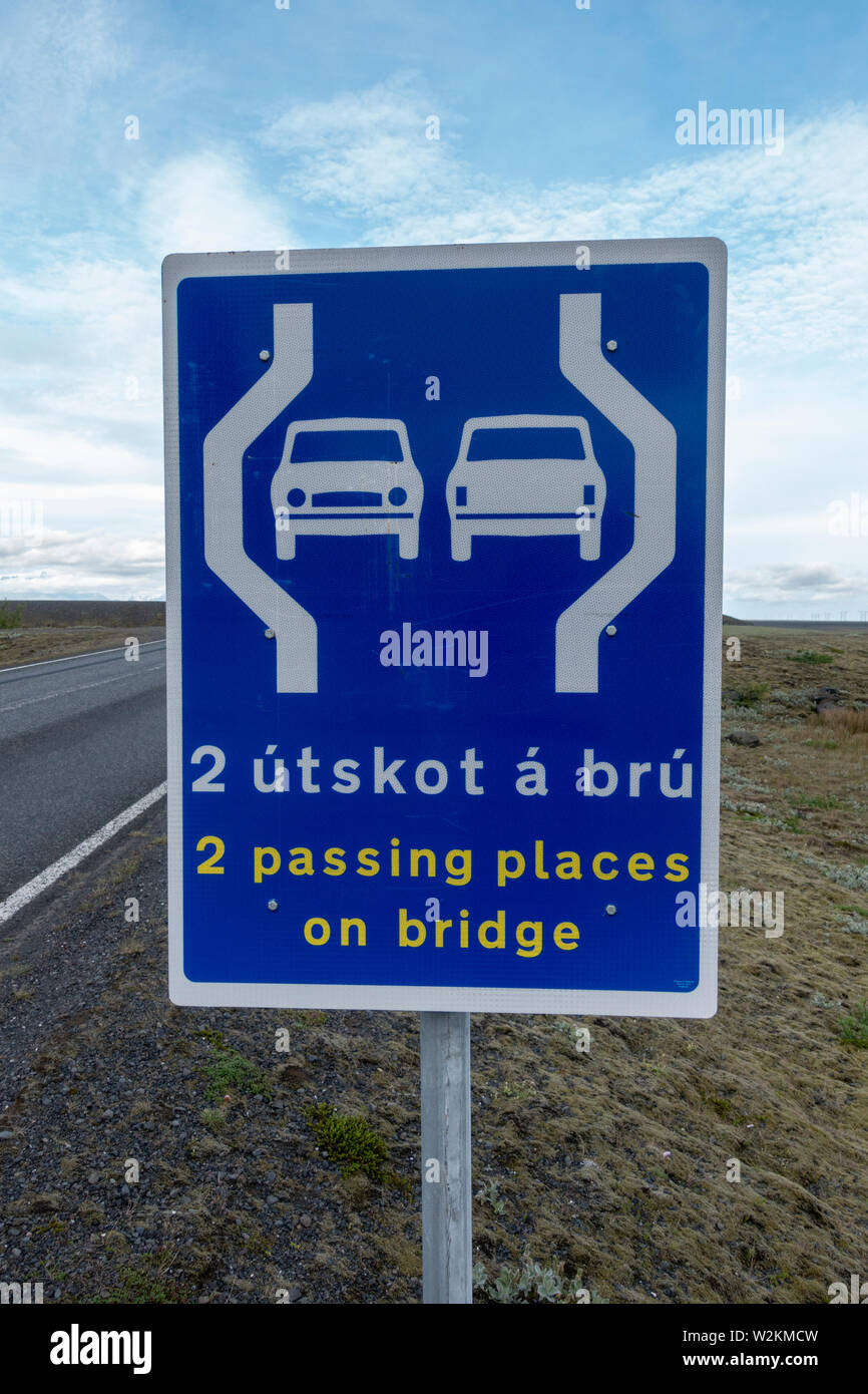 Sign advising drivers that the one-lane bridge ahead has two passing places, near Lómagnúpur, southern Iceland. Stock Photo