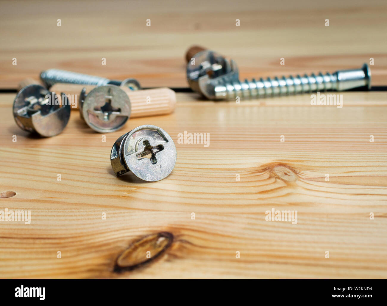 Construction tools. The screws, nuts and bolts on wooden background