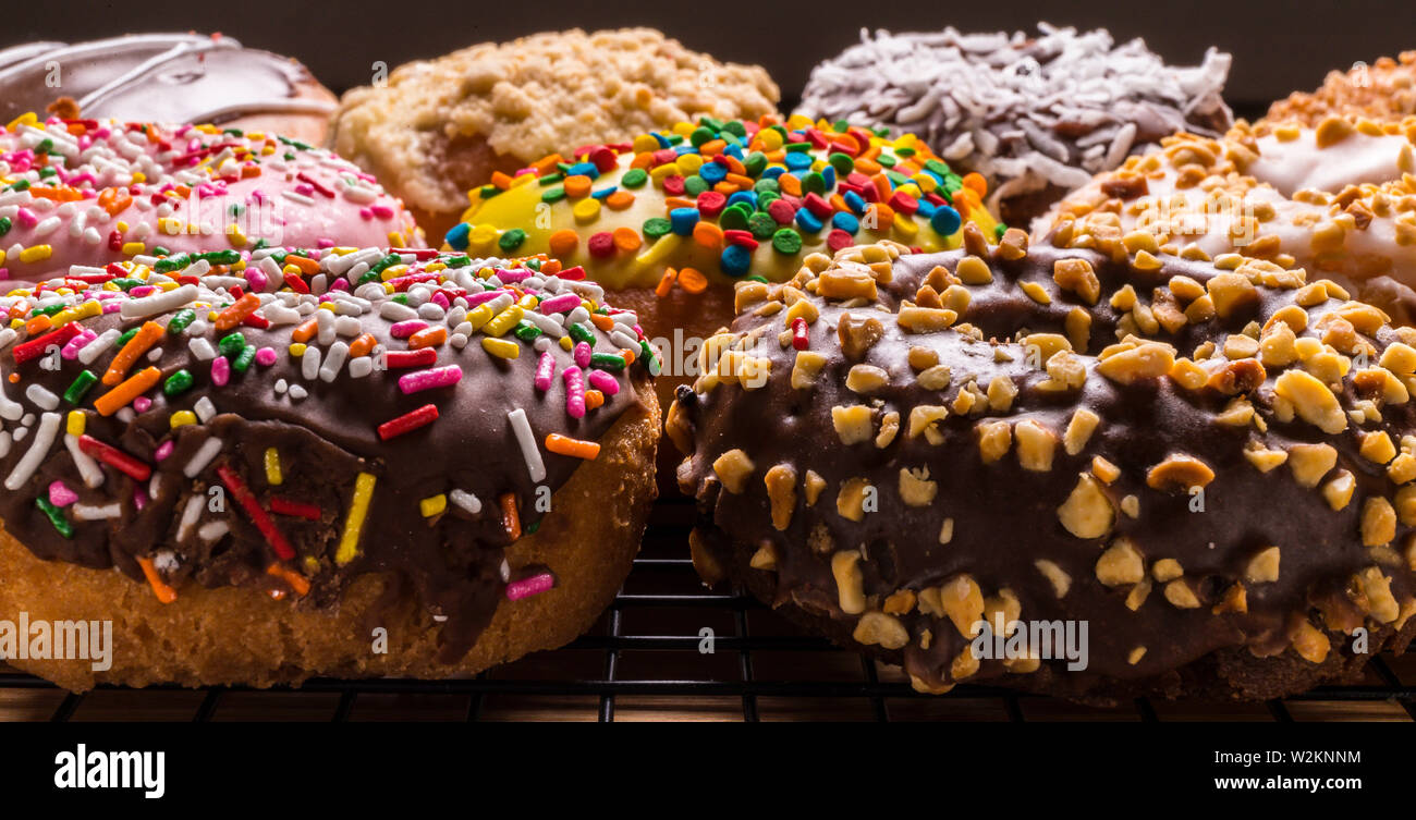 assorted donuts on wire rack on wooden cutting board Stock Photo