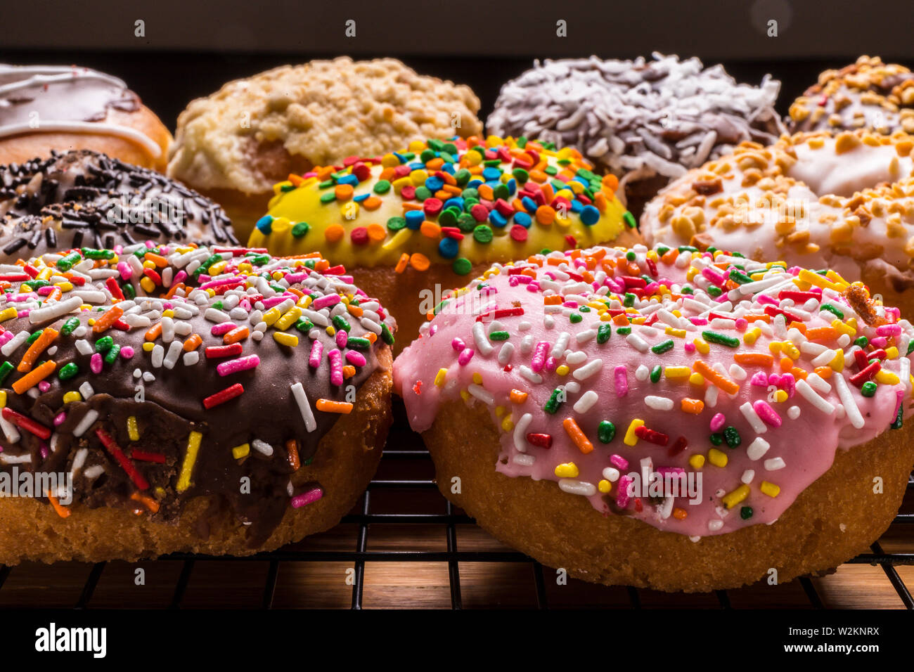 assorted donuts on wire rack on wooden cutting board Stock Photo