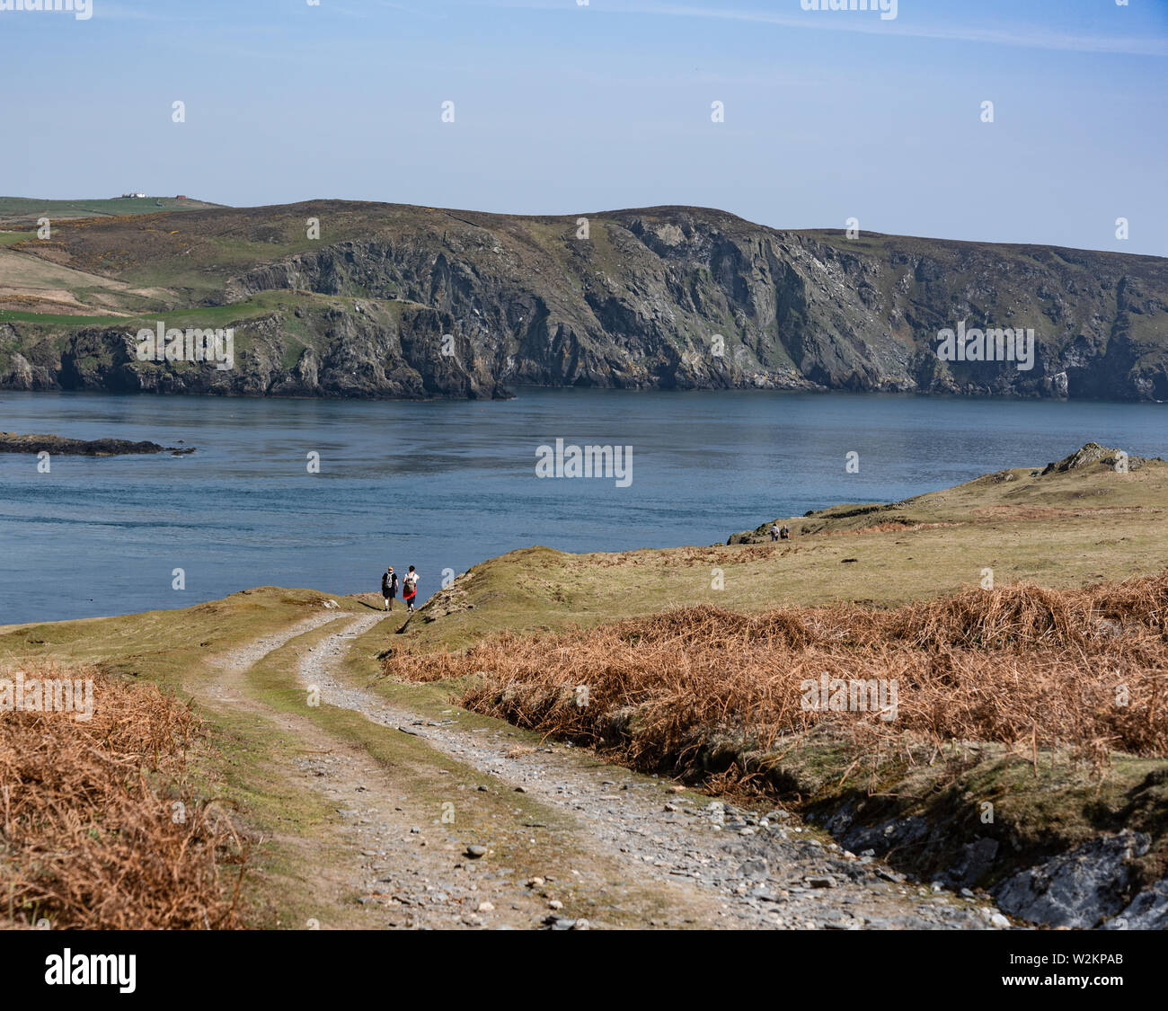 Track road on Calf Of Man with two people walking in the distance Stock Photo