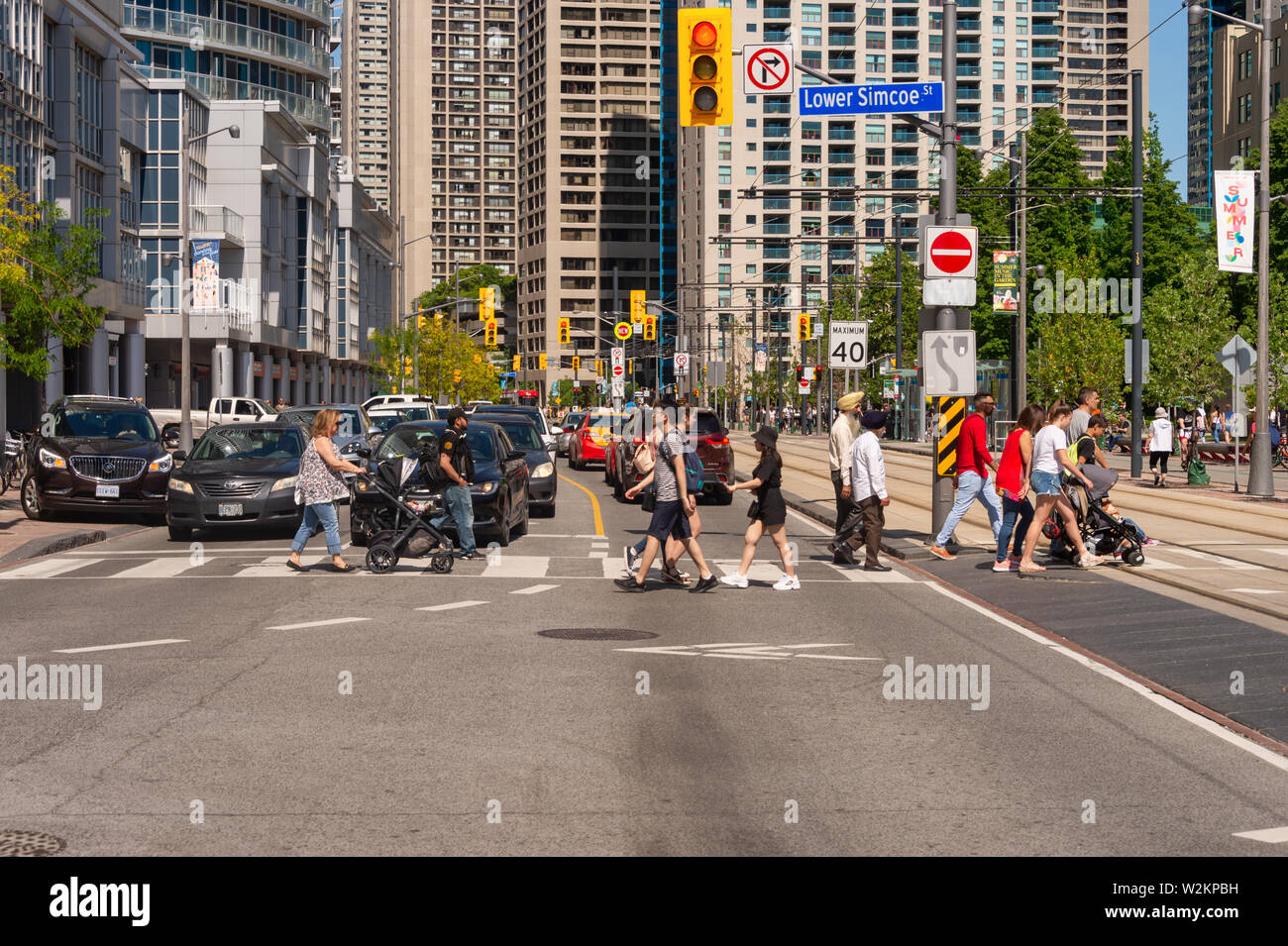 Toronto, Canada - 22 June 2019: A crowd of people crossing Queens Quay W street in Downtown Toronto Stock Photo