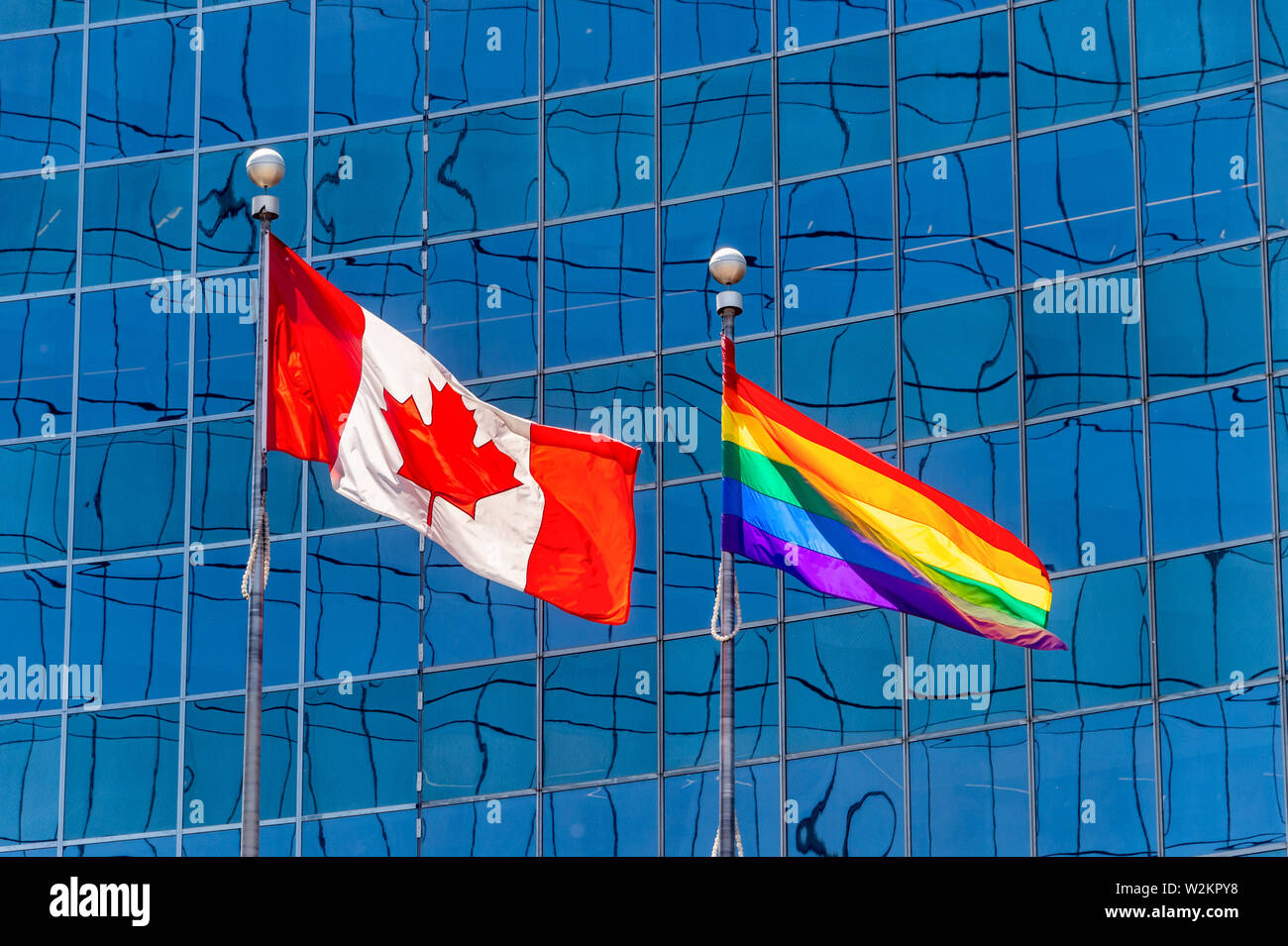 Canadian flag next to rainbow flag in Toronto, Canada Stock Photo