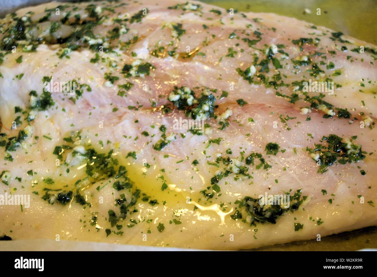baked white fish fillet with oil and parsley Stock Photo - Alamy