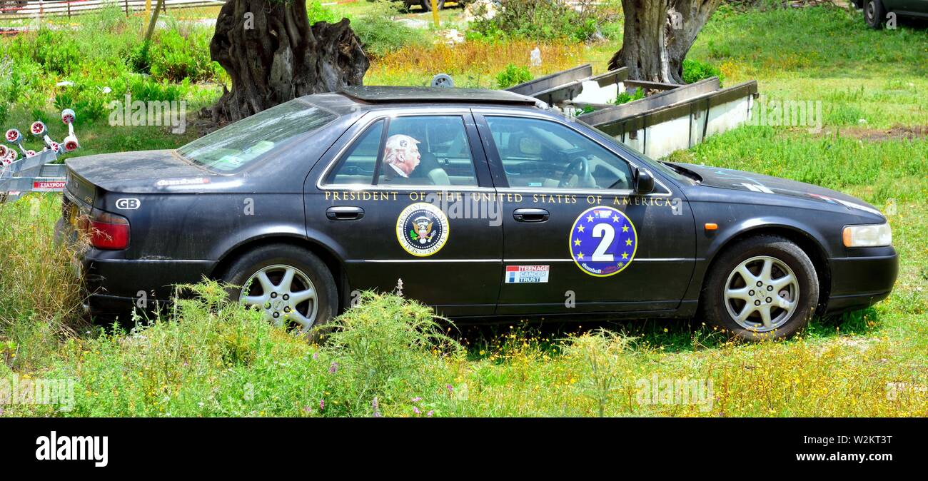 Cadillac car parked in a field,with a picture of Donald Trump in the window,Corfu,Greece Stock Photo