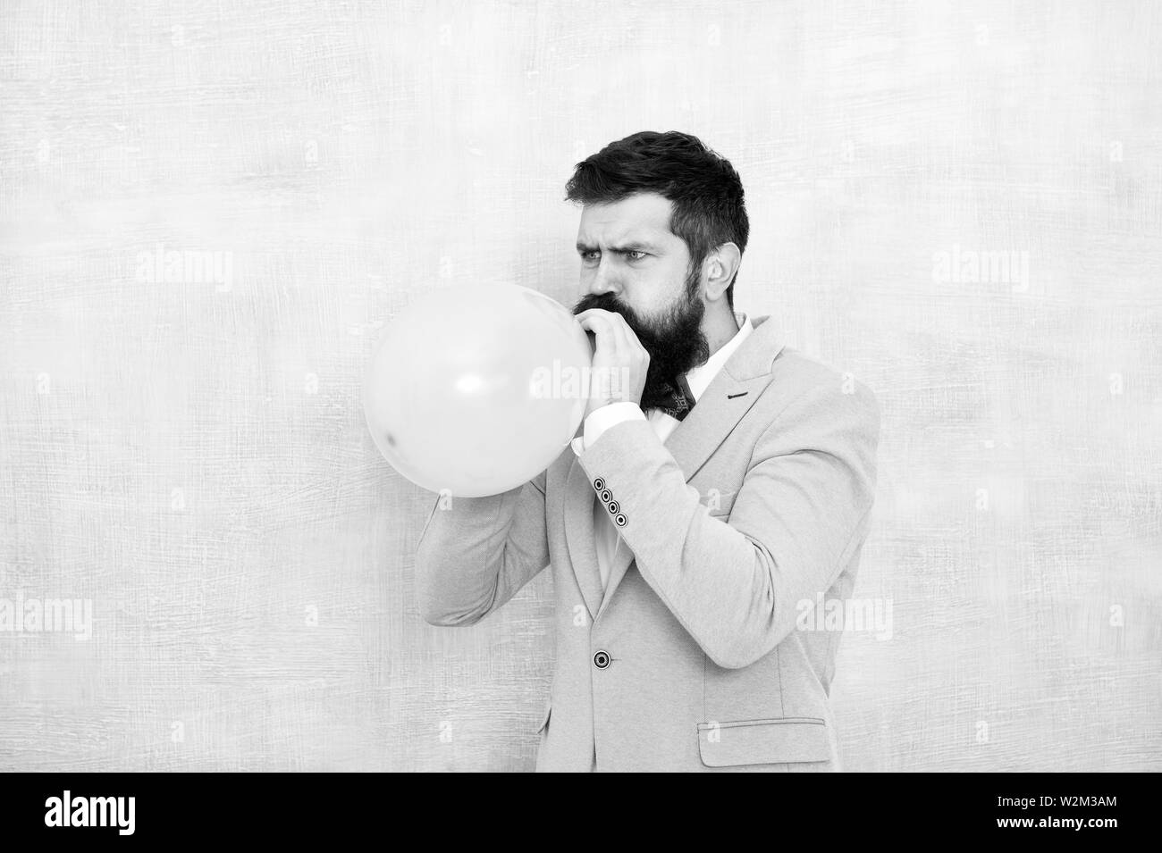 Man inflating a blue balloon. Bearded man with balloon. Happy birthday. preparation to party