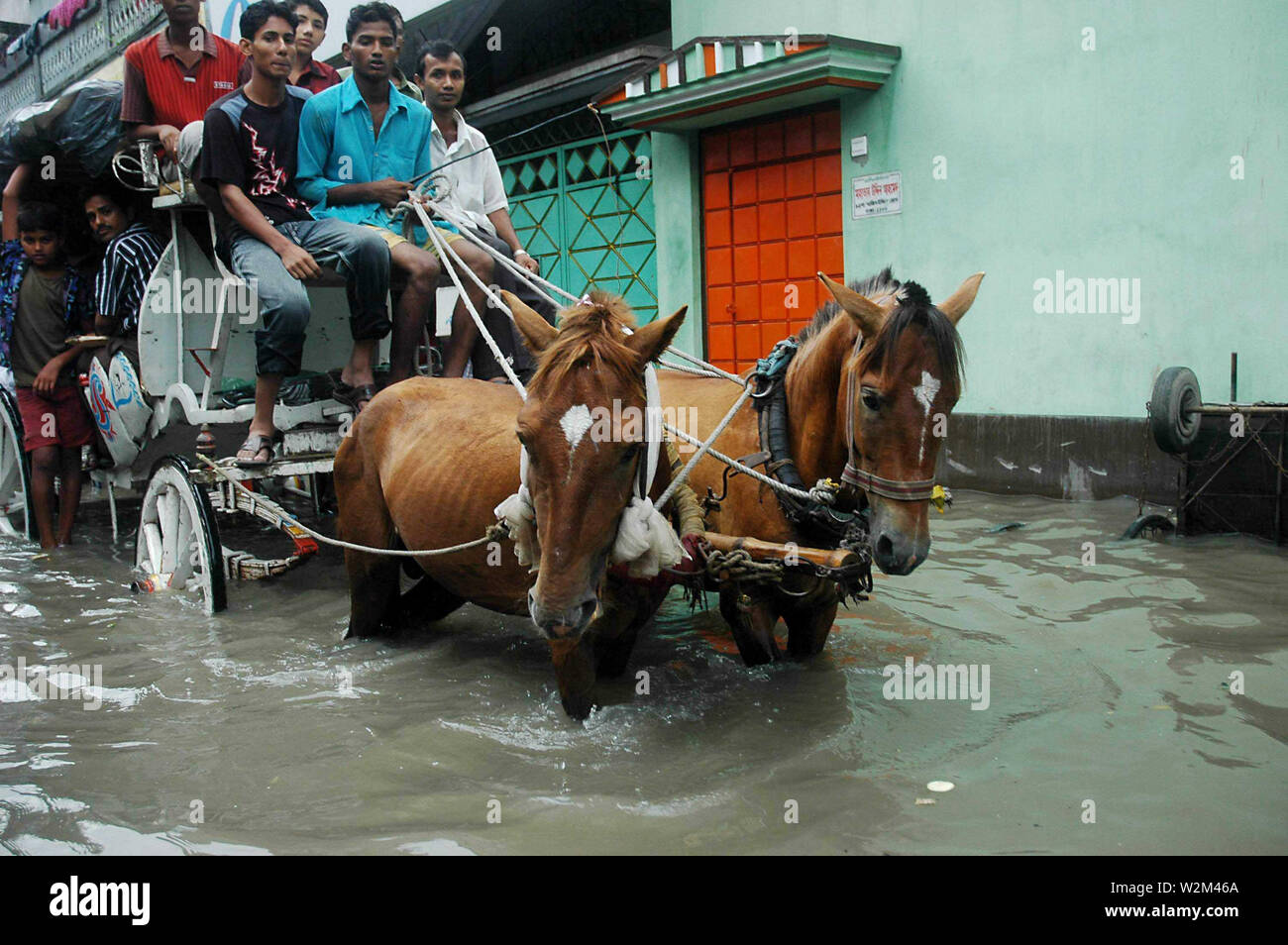 People traveling along a flooded road in ‘Old Dhaka’, on a carriage, during monsoon. Dhaka, Bangladesh. 2007. Stock Photo