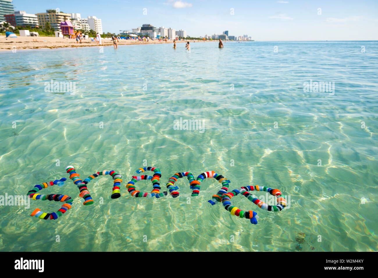 Colorful bottle caps spell out the word 'shame' floating on the sea, an awareness message to rethink single-use plastic and reduce, reuse and recycle Stock Photo