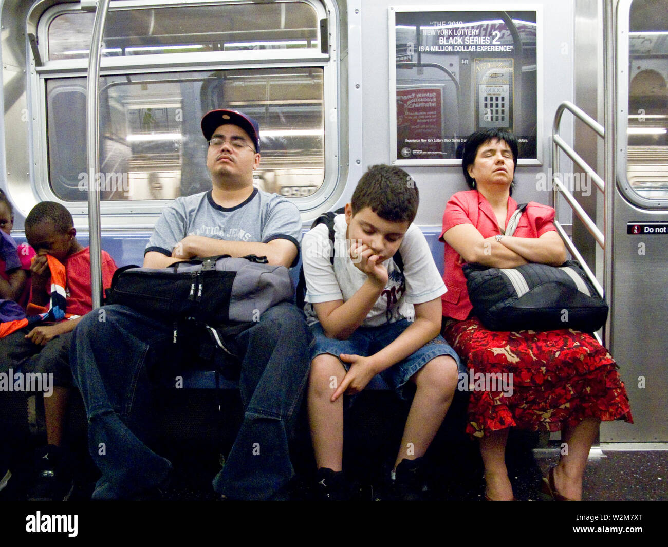 3 asians rest on a train in the NYC subway Stock Photo