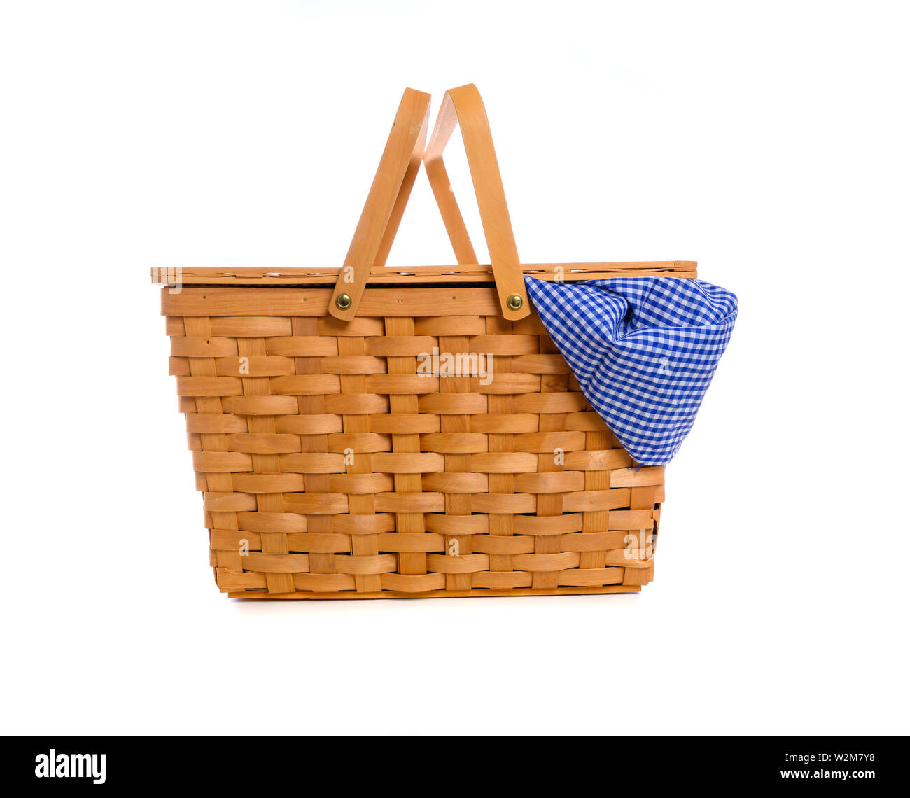 A brown wicker picnic basket on a white background with gingham cloth ...