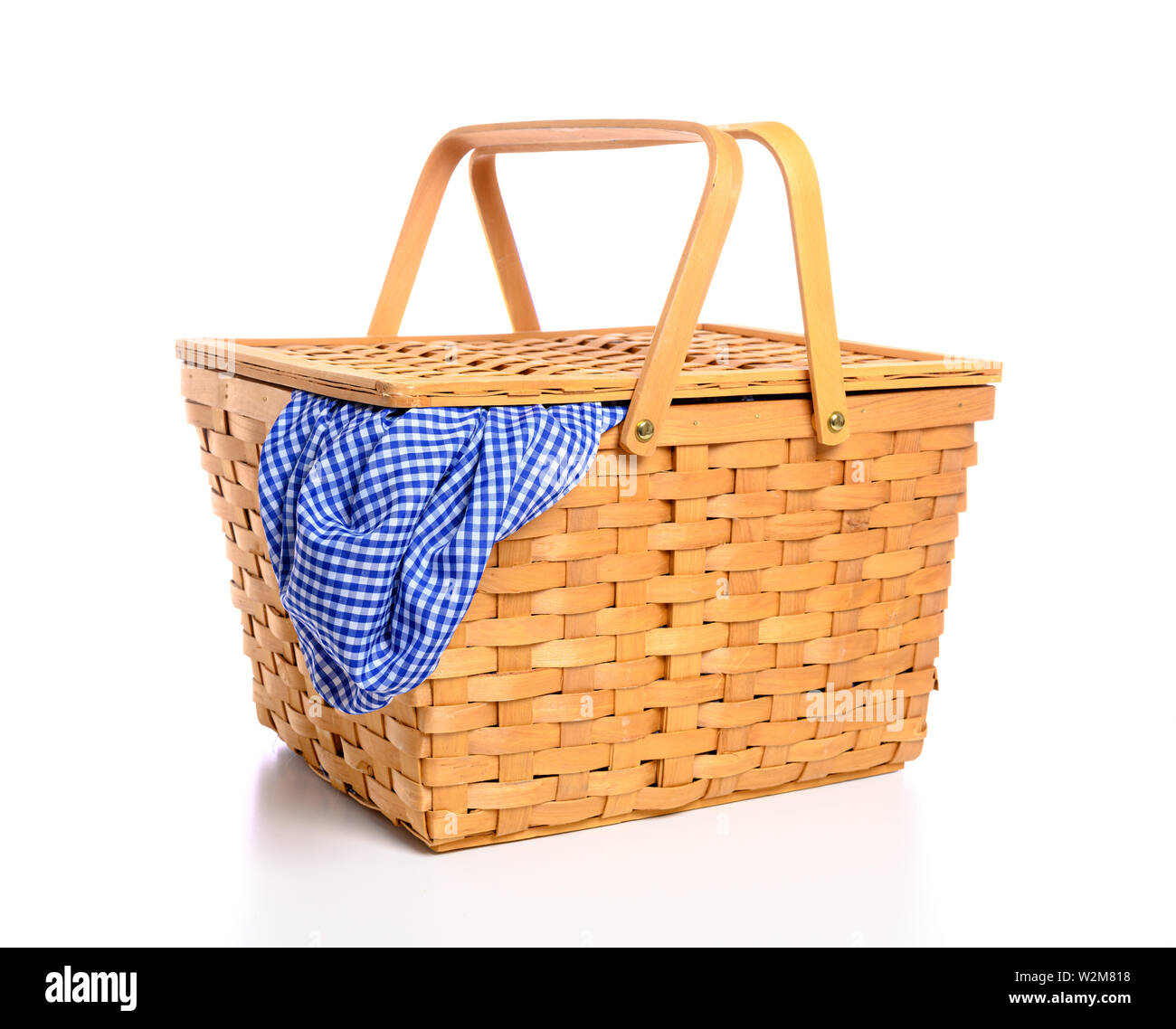 A brown wicker picnic basket on a white background with gingham cloth ...