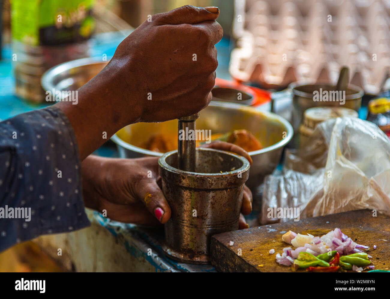Close up of Mortar and Pestle set with a man's hand during grinding spices. Stock Photo