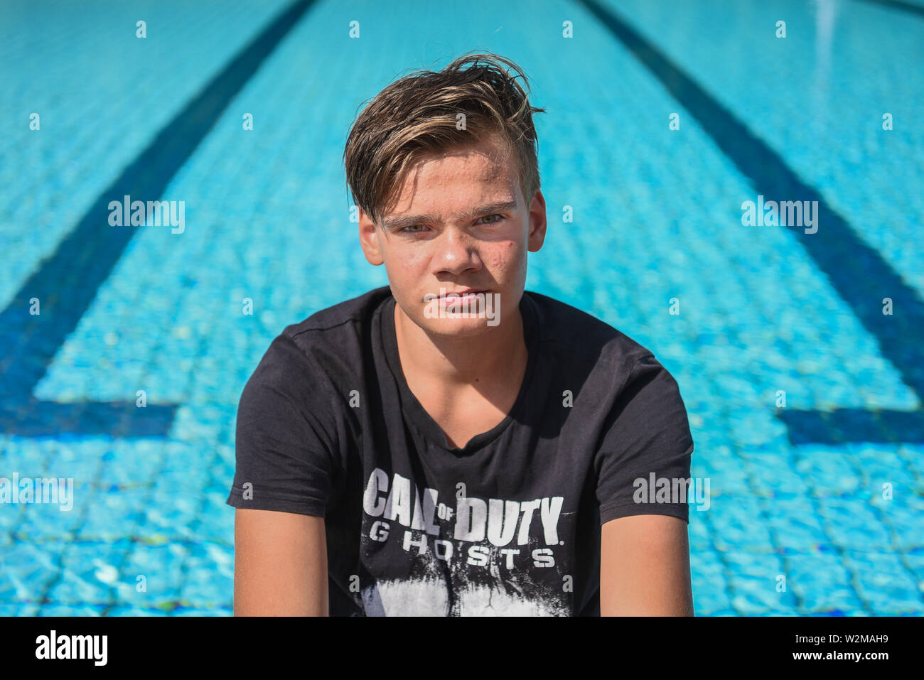 Windischeschenbach, Germany. 08th July, 2019. Justin Fischer sits on the edge of the non-swimmer's pool in the outdoor pool. The 13-year-old saved the life of a four-year-old boy on June 4. Justin noticed the boy at the bottom of the non-swimmer's pool, pulled him out of the water and called adults for help, who immediately started a cardiac massage. Credit: Nicolas Armer/dpa/Alamy Live News Stock Photo