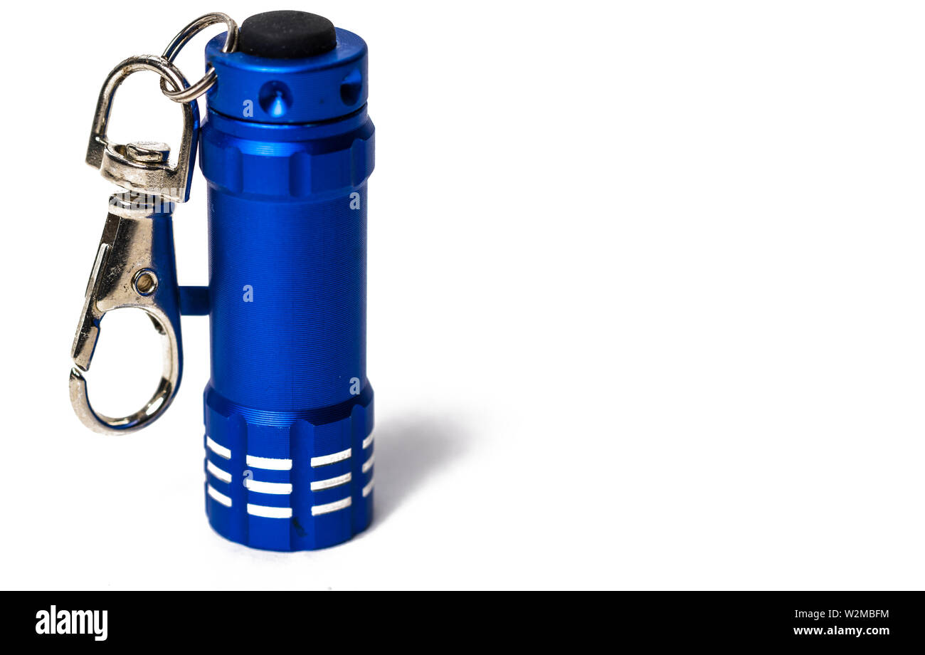 Standing Small blue flashlight key chain on white paper background Stock Photo