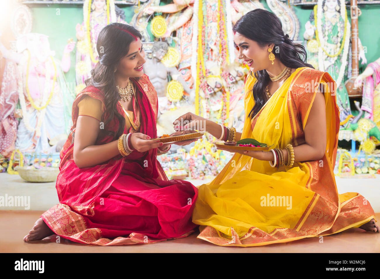 Two bengali women doing prepartion for Pooja Stock Photo